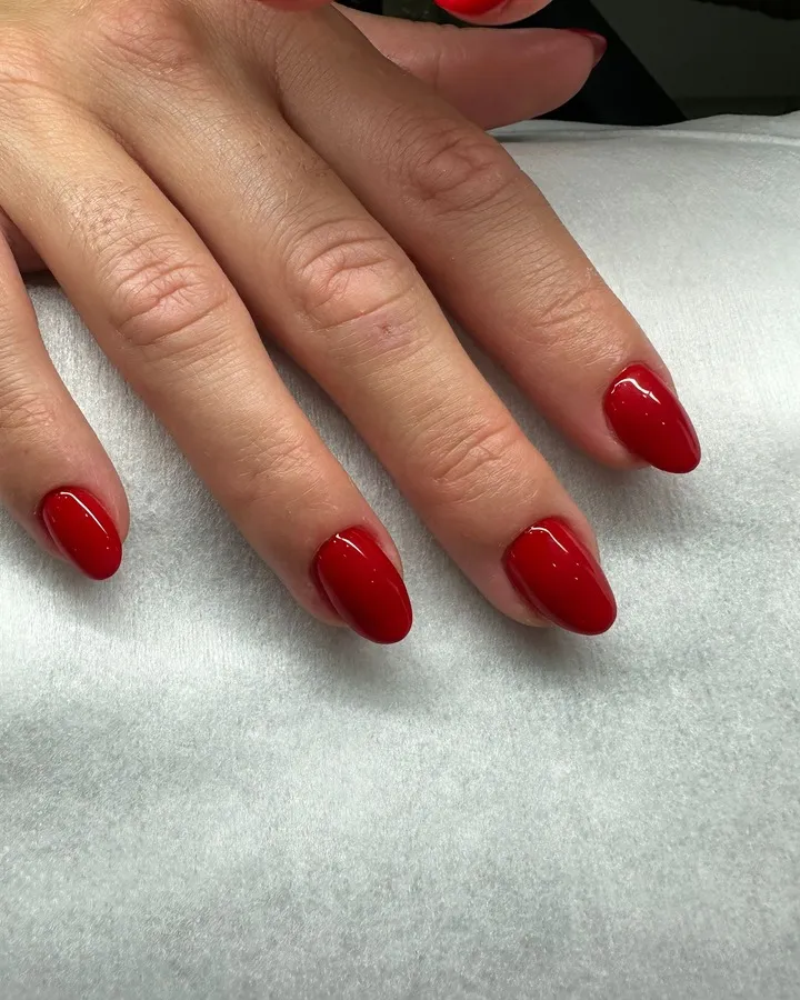 Manicura roja brillante en uñas cortas y redondeadas