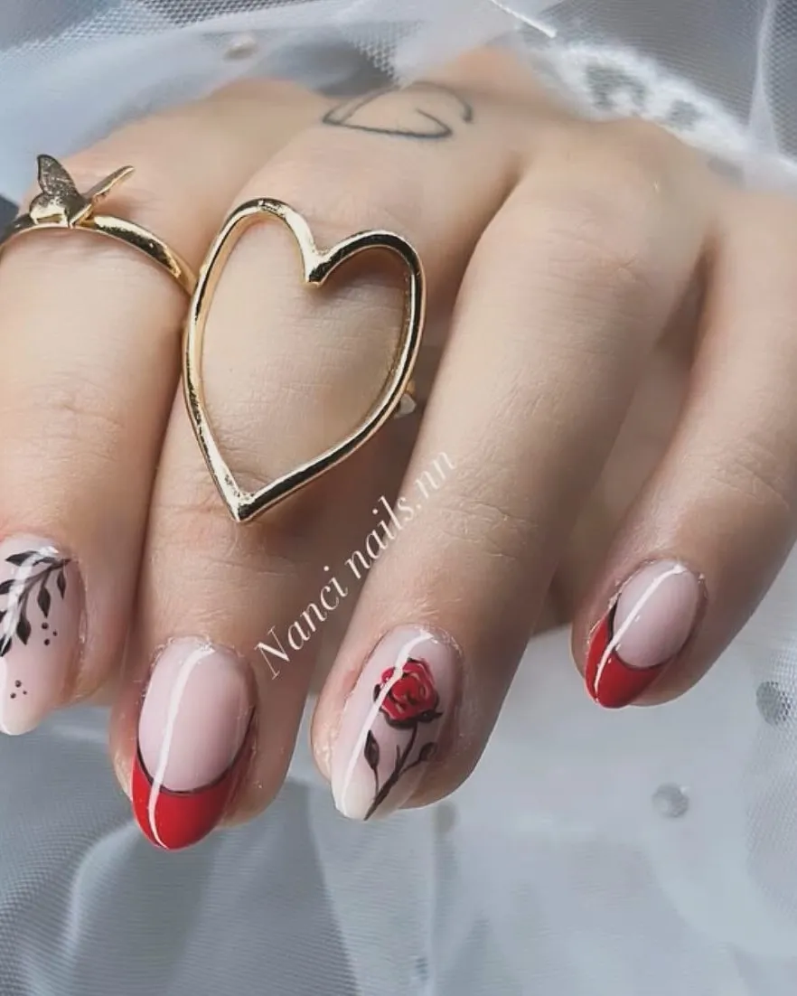 Manicura roja con una rosa y hojas pintadas a mano sobre base nude