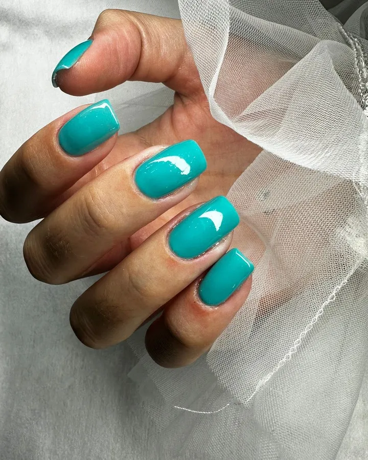 Manicura turquesa brillante en uñas de forma cuadrada